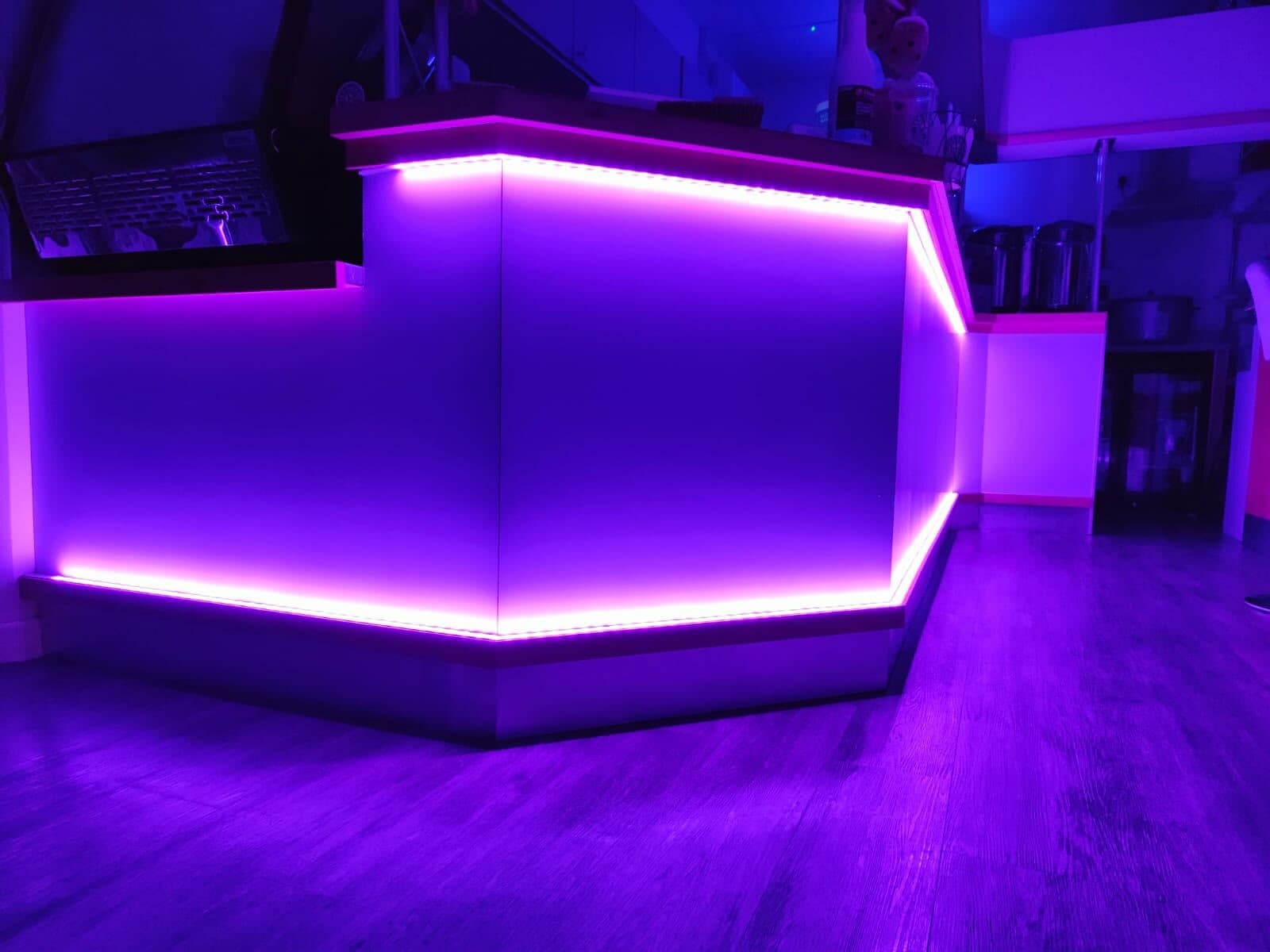Bar counter lit with purple LED strip lighting along the top and the base