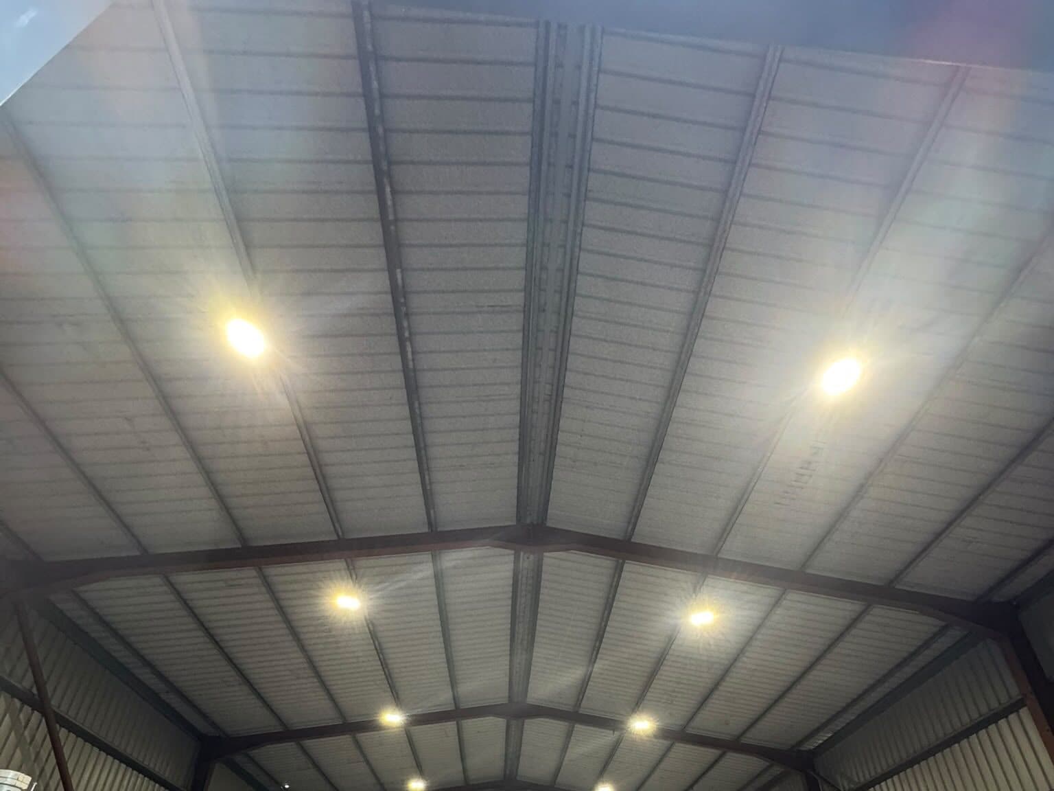 Warehouse roof with new round LED lights fitted along the steel beams